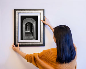 大きな石のアーチの下に立つベトナム人女性の白黒の肖像画