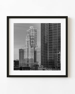 Wrigley Building clock tower among Chicago high rises in black and white