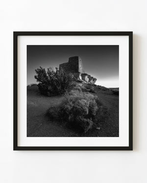 Wukoki Pueblo ruins above desert brush in Arizona in black and white