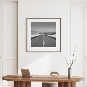 Square landscape photograph of an open road disappearing into rolling hills