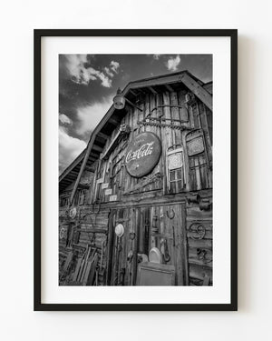 Rustic wooden storefront in Yahk with a vintage Coca-Cola sign in black and white