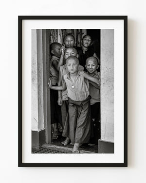 Young monks gathered in an Indian temple doorway in black and white