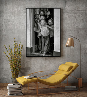 Candid group portrait of young monks gathered closely in an Indian doorway