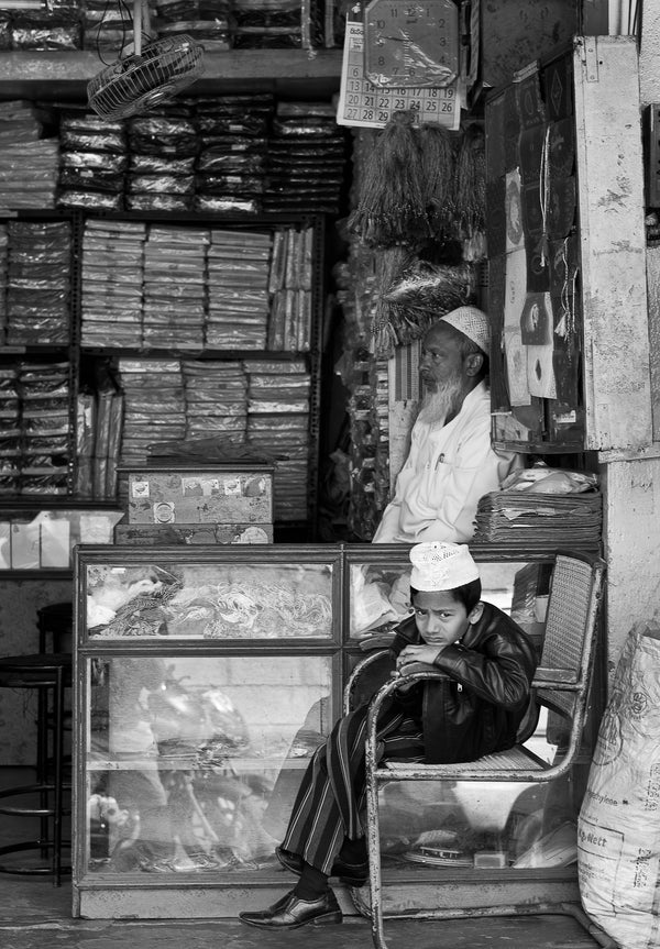 Muslim boy sitting in father’s shop