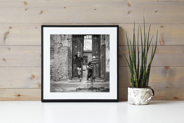 Young and friendly Cuban boys standing at a gated entrance | Wall Art