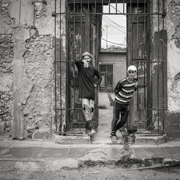 Young and friendly Cuban boys standing at a gated entrance | Wall Art