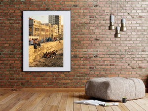 Candid photo of people sitting by seawall in Cuba