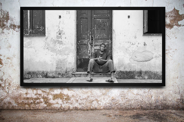 Young man sitting on a doorstep in rural Cuba | Wall Art