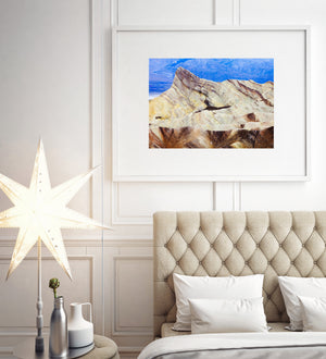 Eroded Death Valley hills with golden slopes and cool distant mountain tones