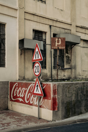 Colour photograph of traffic signs against an aged industrial facade in Zagreb