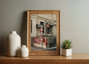 Stacked red edged road signs above a worn Coca-Cola wall sign