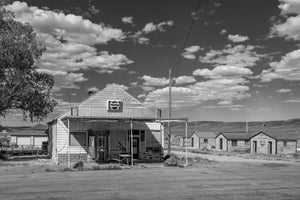Weathered wooden storefront beneath a cloud filled Nevada sky