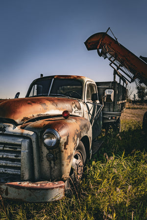 Weathered farm truck surrounded by tall prairie grass
