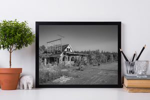 Old roadside motel with roof frame and vacant paved parking area