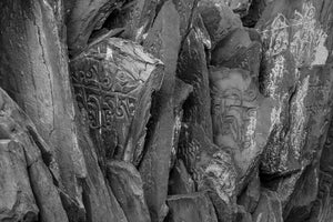 Black and white photograph of stacked Tibetan stone tablets