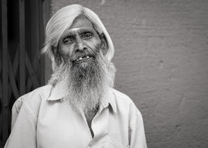 Older man with long white beard smiling at camera