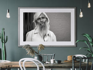 Elderly bearded man beside textured wall in India