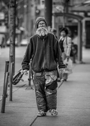 Ritratto di un uomo barbuto in una strada di Toronto sullo sfondo di pedoni e vetrine delicatamente sfocate.