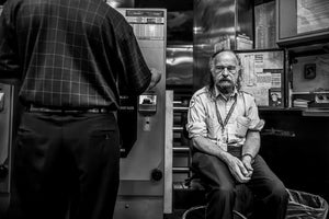 Boston transit worker seated beside subway fare machines