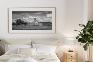 Train moving past old grain elevator in Saskatchewan countryside