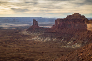 Layered Utah canyon landscape beneath a broad cloud-filled sky