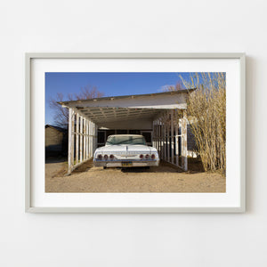 Classic white Chevrolet beneath a weathered carport in Keeler California