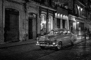 Vintage Cuban taxi parked on an illuminated Havana street