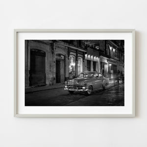 Black and white photograph of a classic taxi in Havana at night