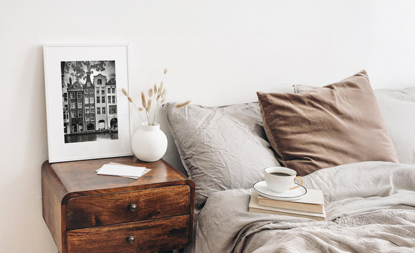 Large framed black and white photograph above a bed in a calming bedroom