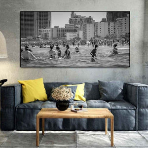 Black and white South Beach photograph showing layered swimmers crowd and city buildings