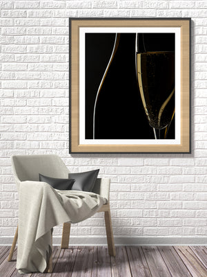 Dark bottle intersecting an illuminated wine flute
