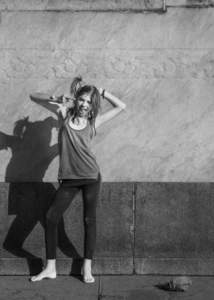 Buenos Aires street portrait of young girl against stone wall in strong sunlight