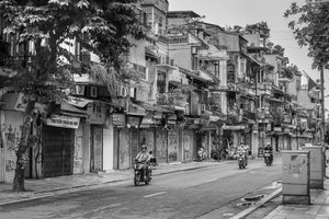 Early morning street scene with motorcycle riders in Hanoi