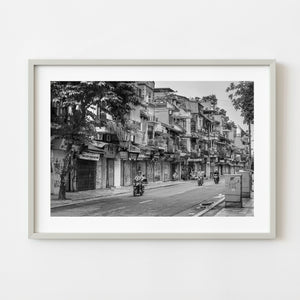 Black and white Hanoi street with scooters and old buildings