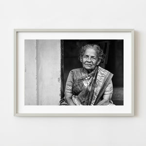 Elderly Indian woman wearing a patterned saree in black and white