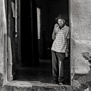 Black and white portrait of an elderly man wearing a hat in Cuba
