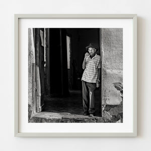 Elderly man standing in a Cuban doorway in black and white
