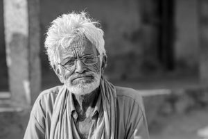 Elderly man with white hair beard and glasses in black and white