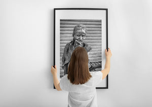 Woman with silver hair standing before a metal shutter
