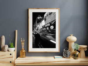 Black and white New York street photograph with moving headlights