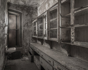 Abandoned hospital interior on Ellis Island with open wooden cupboards