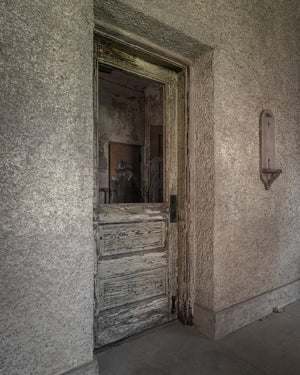 Weathered wooden hospital door with peeling paint on Ellis Island