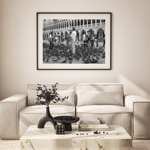 Black and white Venice street scene with tourists and flying pigeons