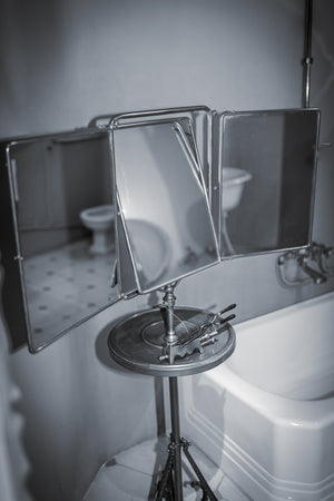 Vintage metal bathroom mirror beside white bathtub in Spain