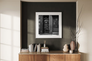 Weathered storefront entrance with worn wooden trim and graffiti in black and white