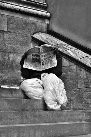 Black and white Manhattan street scene with man behind newspaper