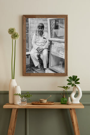 Indian street portrait with seated man and glass shop display
