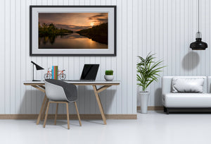 Wide landscape view of sunset over wooded waterway
