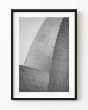 Curving marble petals of the Lotus Temple in New Delhi against a pale sky, photographed in black and white.