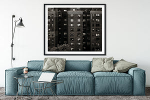 Urban brick building facade with windows curtains and deep shadows